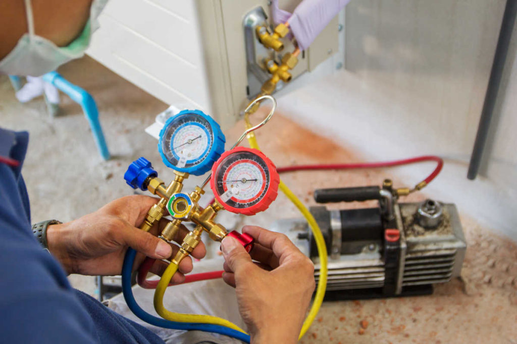 Técnico em ar condicionado fazendo manutenção em sistema de ar condicionado split | Foto: Shutterstock