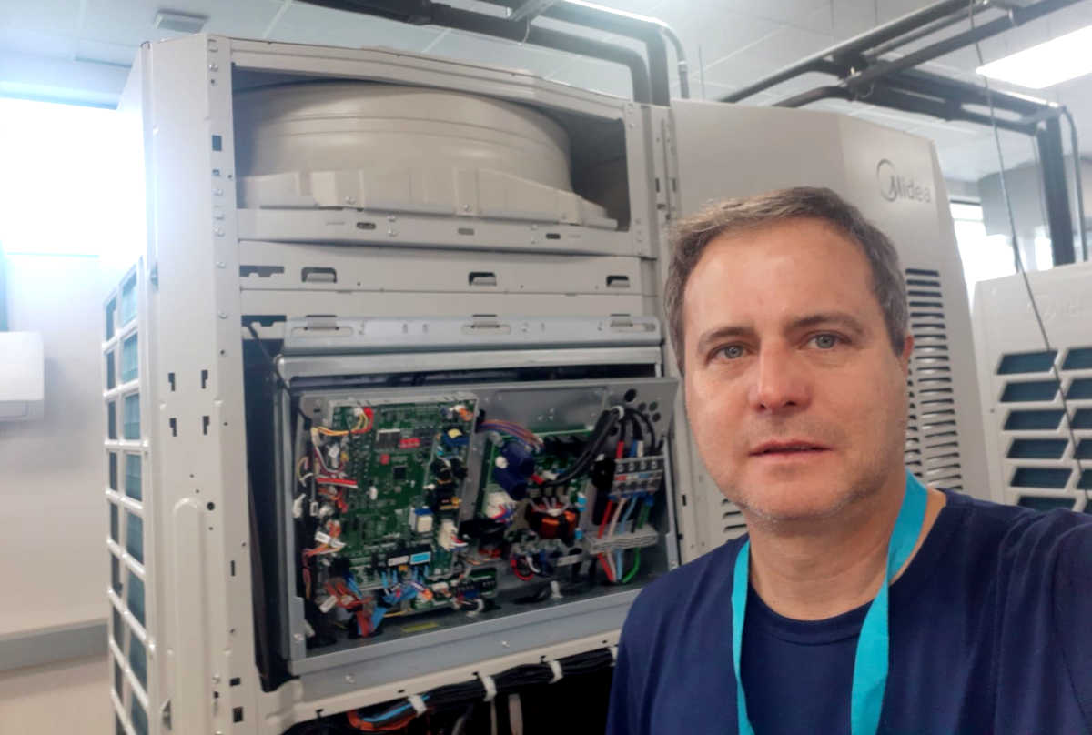 O professor Amércio Martins, diretor da Thermo Curso, ao lado de sistema de ar condicionado com fluxo de refrigerante variável (VRF) | Foto: Divulgação