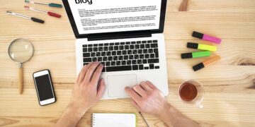 Computador disposto em mesa de redação de blog | Foto: Shutterstock