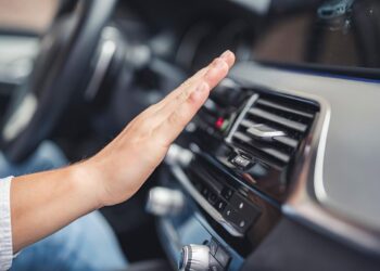Motorista conferindo funcionamento do sistema de ar condicionado em automóvel | Foto: Shutterstock