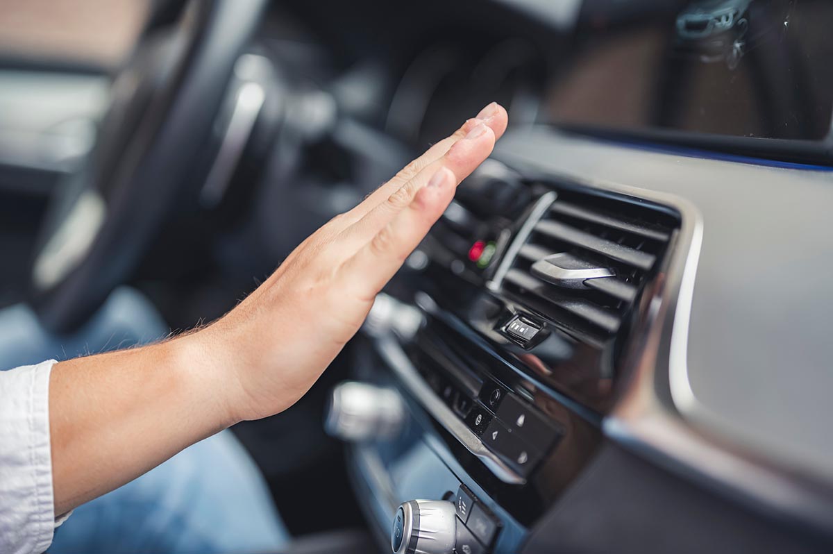 Motorista conferindo funcionamento do sistema de ar condicionado em automóvel | Foto: Shutterstock