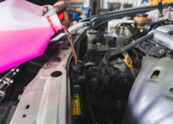 Mecânico automotivo adicionando fluido de arrefecimento em radiador de automóvel | Foto: Shutterstock