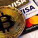 Criptomoeda Bitcoin com closeup de cartões eletrônicos de plástico Visa e Mastercard | Foto: Primakov/Shutterstock