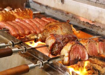 Carnes sendo preparadas no espeto em churrasqueira | Foto: Shutterstock
