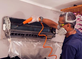 Técnico em refrigeração limpando unidade evaporadora de sistemas de ar condicionado | Foto: Shutterstock
