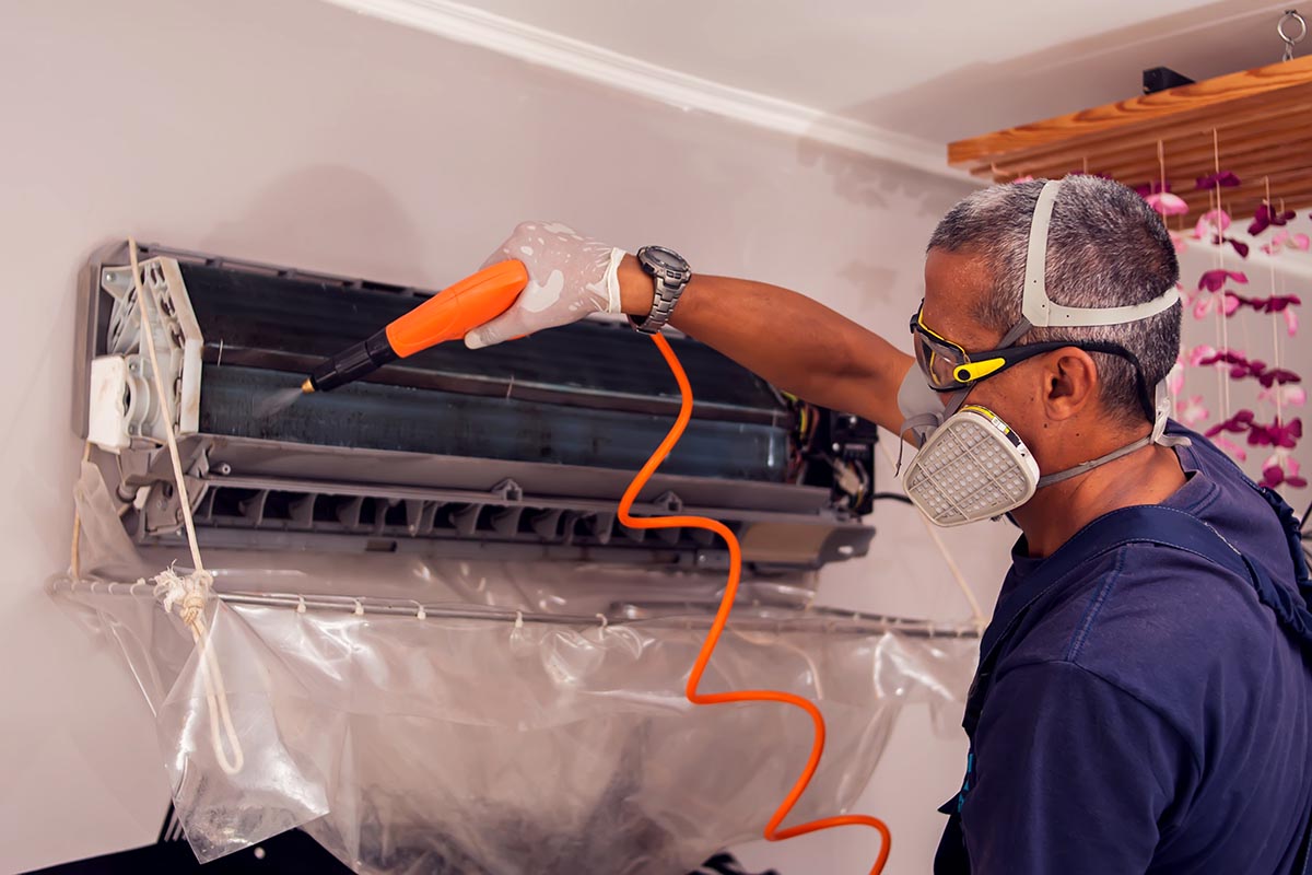 Técnico em refrigeração limpando unidade evaporadora de sistemas de ar condicionado | Foto: Shutterstock